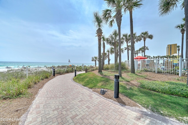 view of property's community with a water view and a beach view