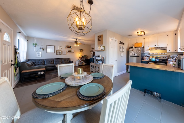 dining room featuring ceiling fan with notable chandelier and light tile patterned flooring