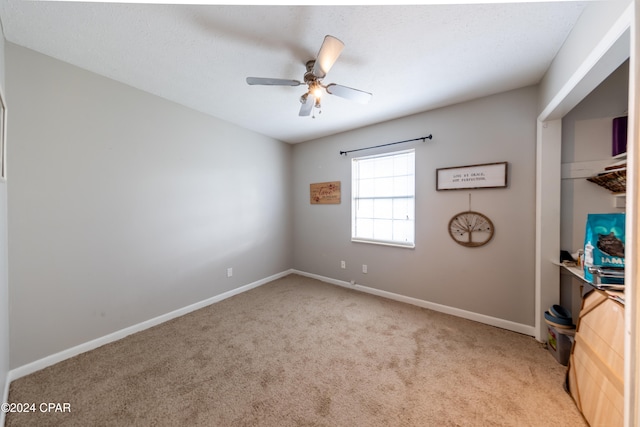 spare room featuring light carpet and ceiling fan