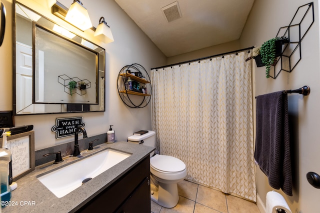 bathroom featuring tile patterned flooring, vanity, toilet, and walk in shower