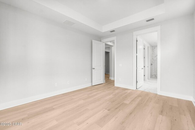 unfurnished bedroom featuring connected bathroom and light wood-type flooring