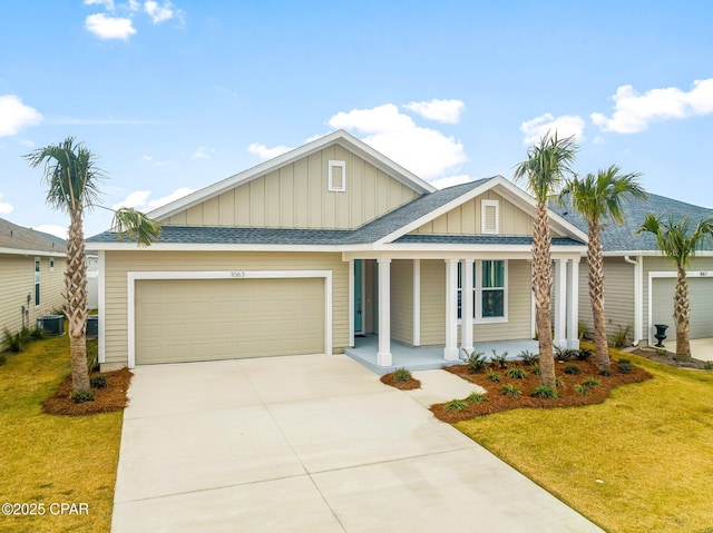 view of front facade with a garage, central AC, and a front lawn