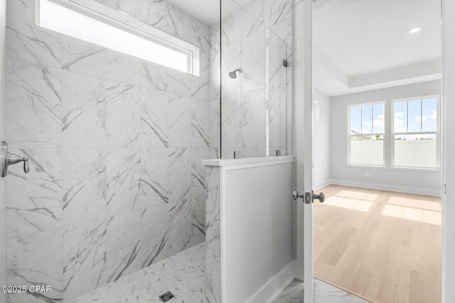 bathroom featuring hardwood / wood-style flooring and a tile shower