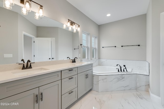 bathroom with tiled bath and vanity