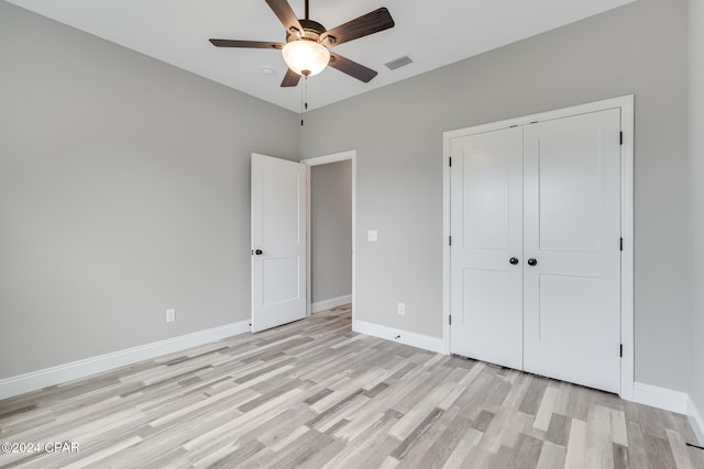 unfurnished bedroom with ceiling fan, a closet, and light hardwood / wood-style floors