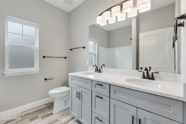 bathroom with a shower, vanity, hardwood / wood-style flooring, and toilet