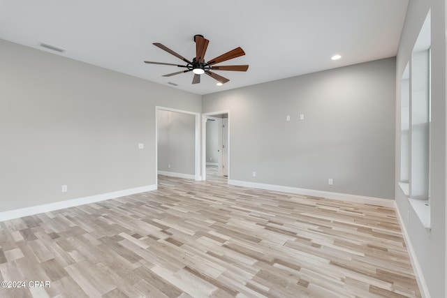 empty room with ceiling fan and light hardwood / wood-style flooring