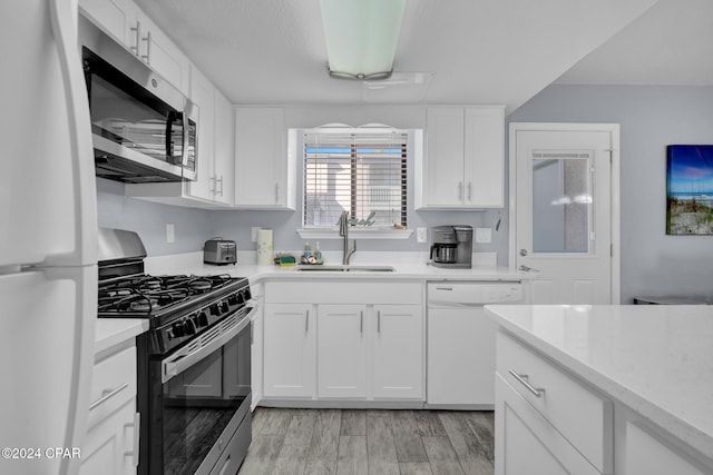 kitchen with sink, stainless steel appliances, light hardwood / wood-style floors, and white cabinets