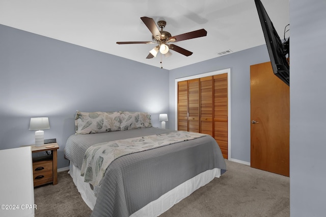 carpeted bedroom featuring ceiling fan and a closet