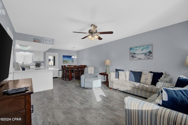 living room with ceiling fan and light hardwood / wood-style flooring