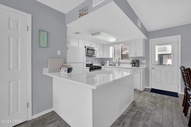 kitchen featuring appliances with stainless steel finishes, white cabinets, and kitchen peninsula