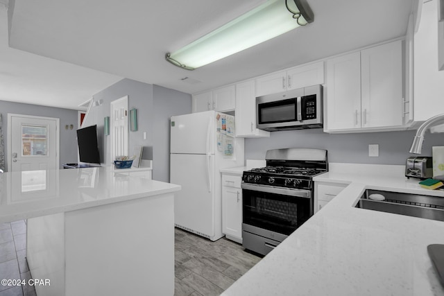 kitchen featuring sink, light wood-type flooring, white cabinets, and appliances with stainless steel finishes