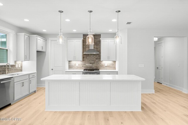 unfurnished living room with a notable chandelier, sink, light hardwood / wood-style floors, and a raised ceiling