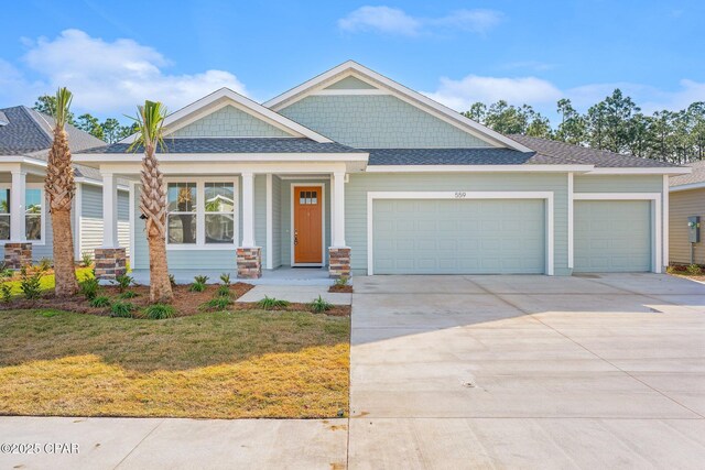 view of front of property with a porch, a front yard, and a garage