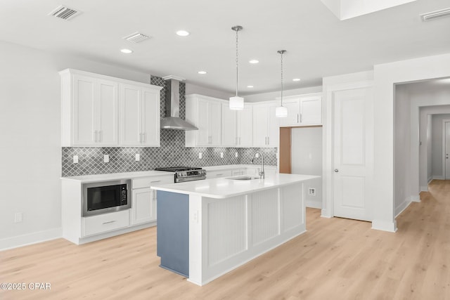 kitchen with white cabinetry, wall chimney range hood, sink, and black microwave