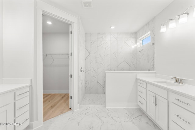 bathroom featuring tiled shower and vanity