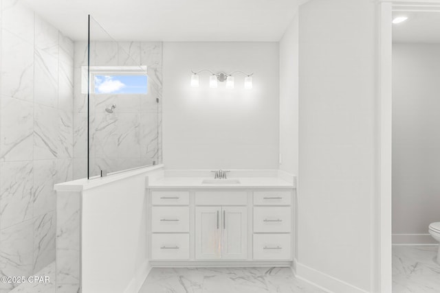 bathroom featuring vanity, tiled shower, and toilet