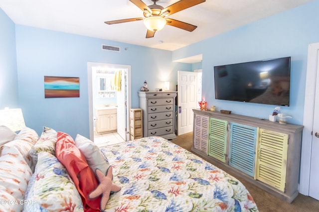 bedroom with ceiling fan, carpet floors, and ensuite bathroom