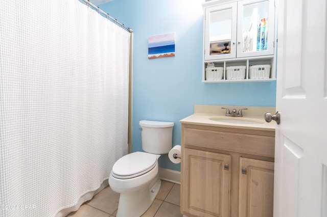 bathroom with toilet, vanity, tile patterned floors, and walk in shower