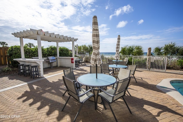 view of patio / terrace featuring exterior bar, a pergola, and a water view