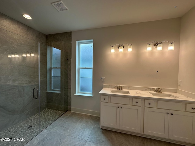 bathroom featuring a wealth of natural light, walk in shower, and vanity