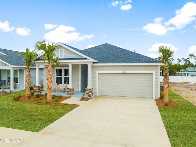 view of front of house featuring a garage, covered porch, and a front lawn