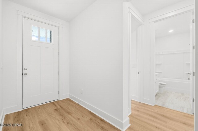 foyer featuring hardwood / wood-style flooring and vaulted ceiling