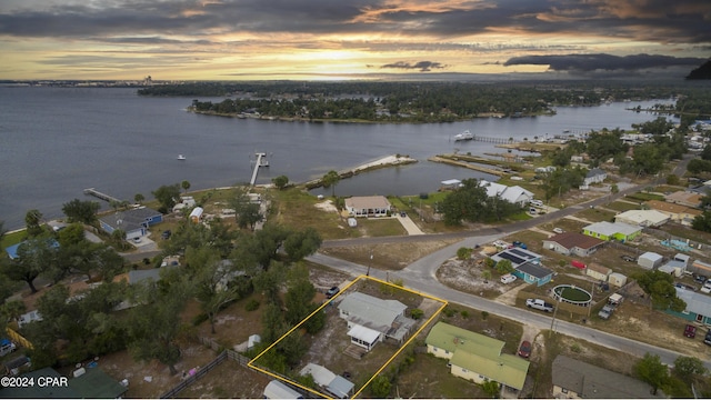 aerial view at dusk featuring a water view