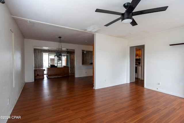 unfurnished living room featuring dark hardwood / wood-style flooring and ceiling fan with notable chandelier