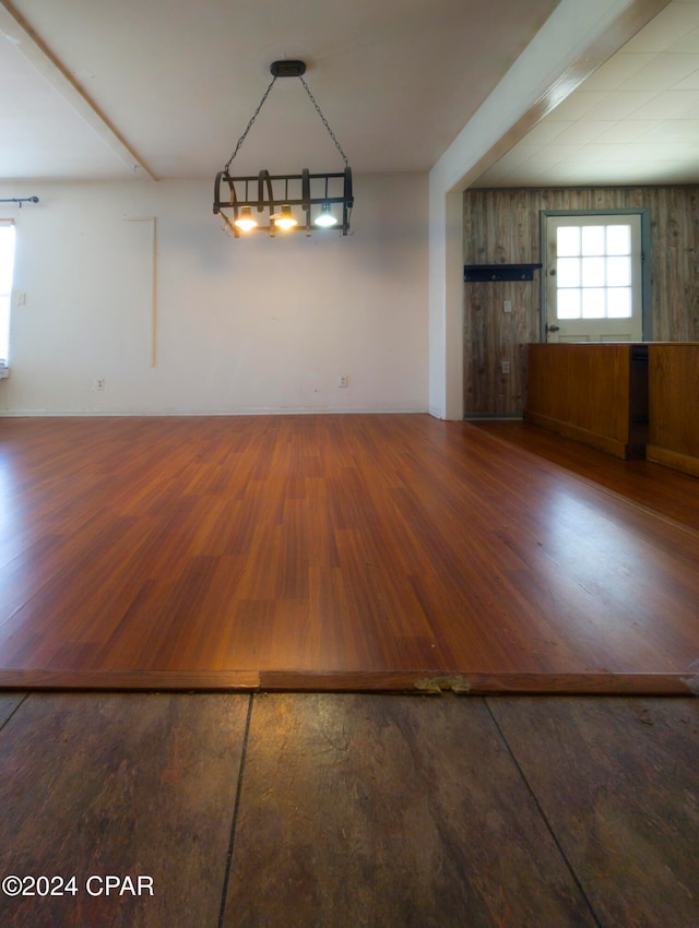 unfurnished dining area featuring dark hardwood / wood-style flooring and wooden walls