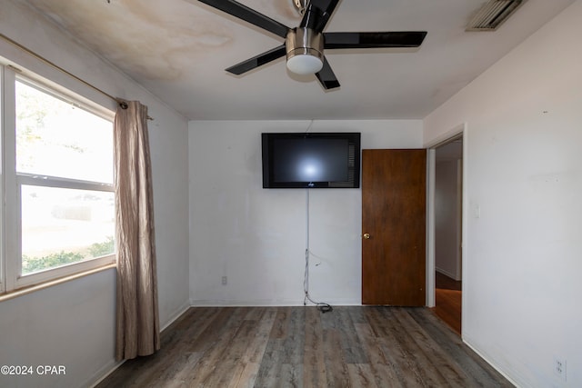 unfurnished bedroom with hardwood / wood-style floors, multiple windows, and ceiling fan