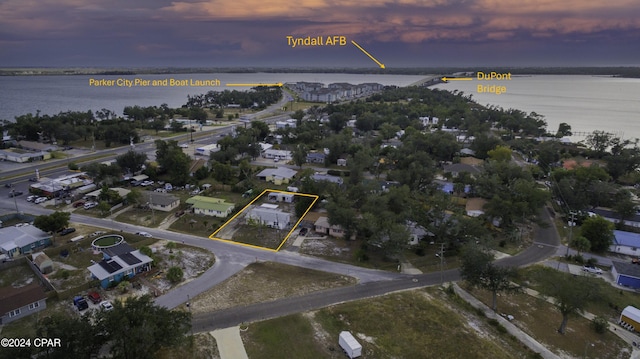 aerial view at dusk featuring a water view