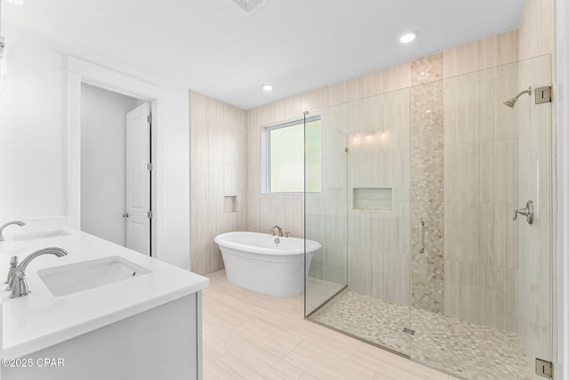 bathroom featuring vanity, separate shower and tub, and tile walls