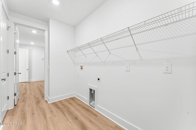 clothes washing area featuring hookup for a washing machine, hookup for an electric dryer, and light hardwood / wood-style floors