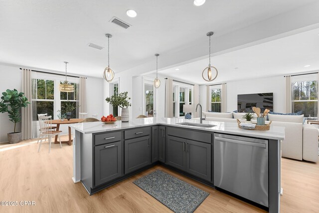 kitchen featuring gray cabinets, sink, hanging light fixtures, stainless steel dishwasher, and light wood-type flooring