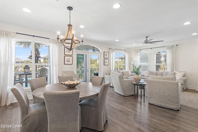 dining space featuring ceiling fan with notable chandelier, a healthy amount of sunlight, and wood-type flooring