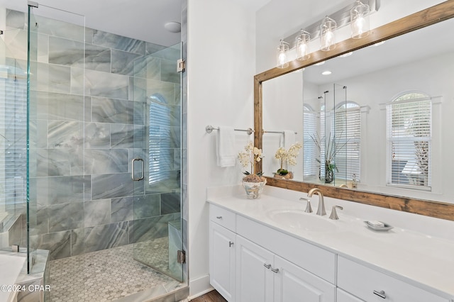 bathroom with a shower with door and vanity