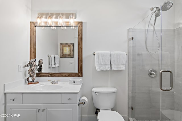 bathroom with vanity, toilet, and a shower with door