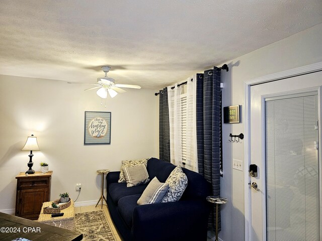 tiled living room featuring ceiling fan and a textured ceiling