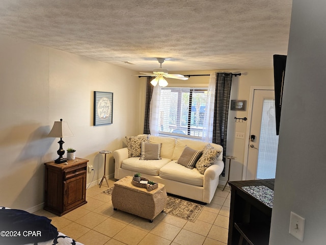 living room with a textured ceiling, ceiling fan, and light tile patterned flooring