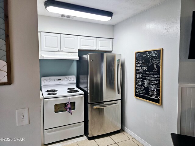 kitchen featuring light tile patterned floors, white electric stove, stainless steel refrigerator, and white cabinets