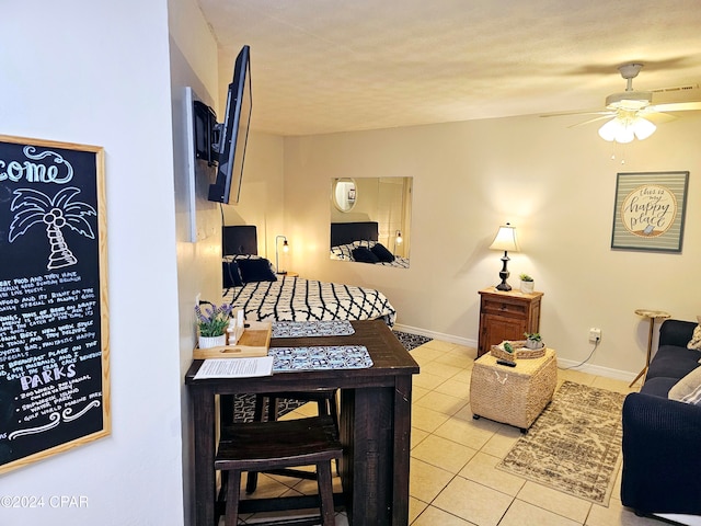 living room featuring a textured ceiling, ceiling fan, and light tile patterned flooring