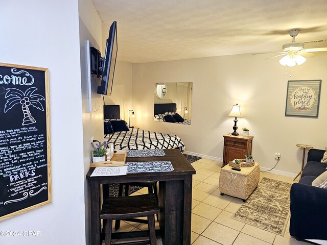 tiled bedroom featuring ceiling fan and a textured ceiling