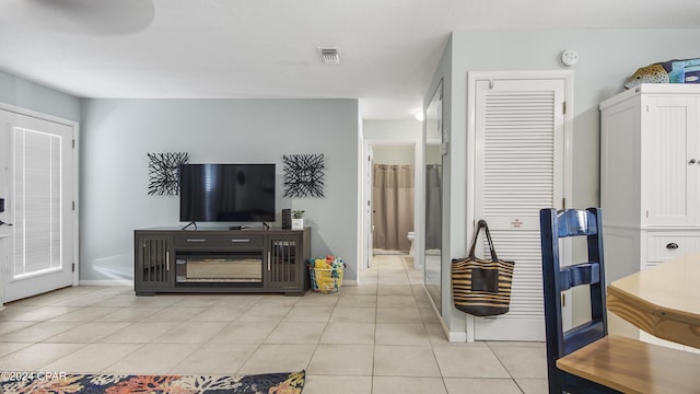 living area with light tile patterned floors, visible vents, and baseboards