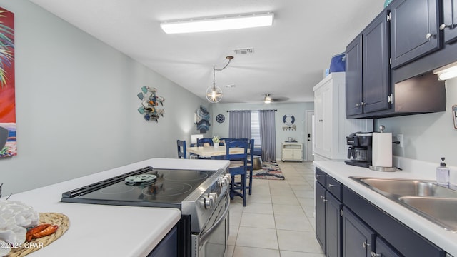 kitchen featuring visible vents, light tile patterned flooring, a sink, light countertops, and stainless steel range with electric stovetop