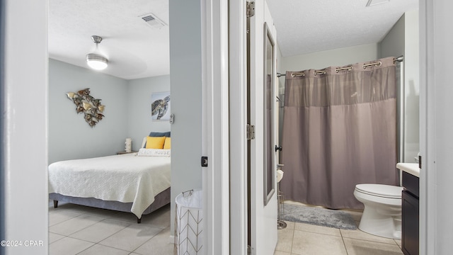 full bathroom with visible vents, toilet, curtained shower, a textured ceiling, and tile patterned flooring