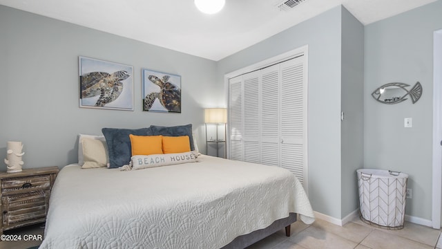 bedroom featuring a closet, visible vents, tile patterned flooring, and baseboards