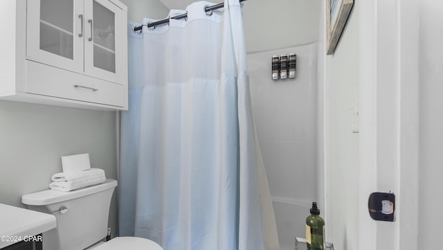 full bath with a shower with shower curtain and toilet