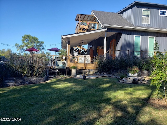 view of side of property featuring ceiling fan and a yard