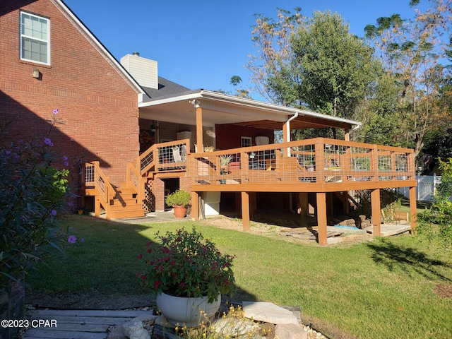 rear view of house featuring a yard and a deck